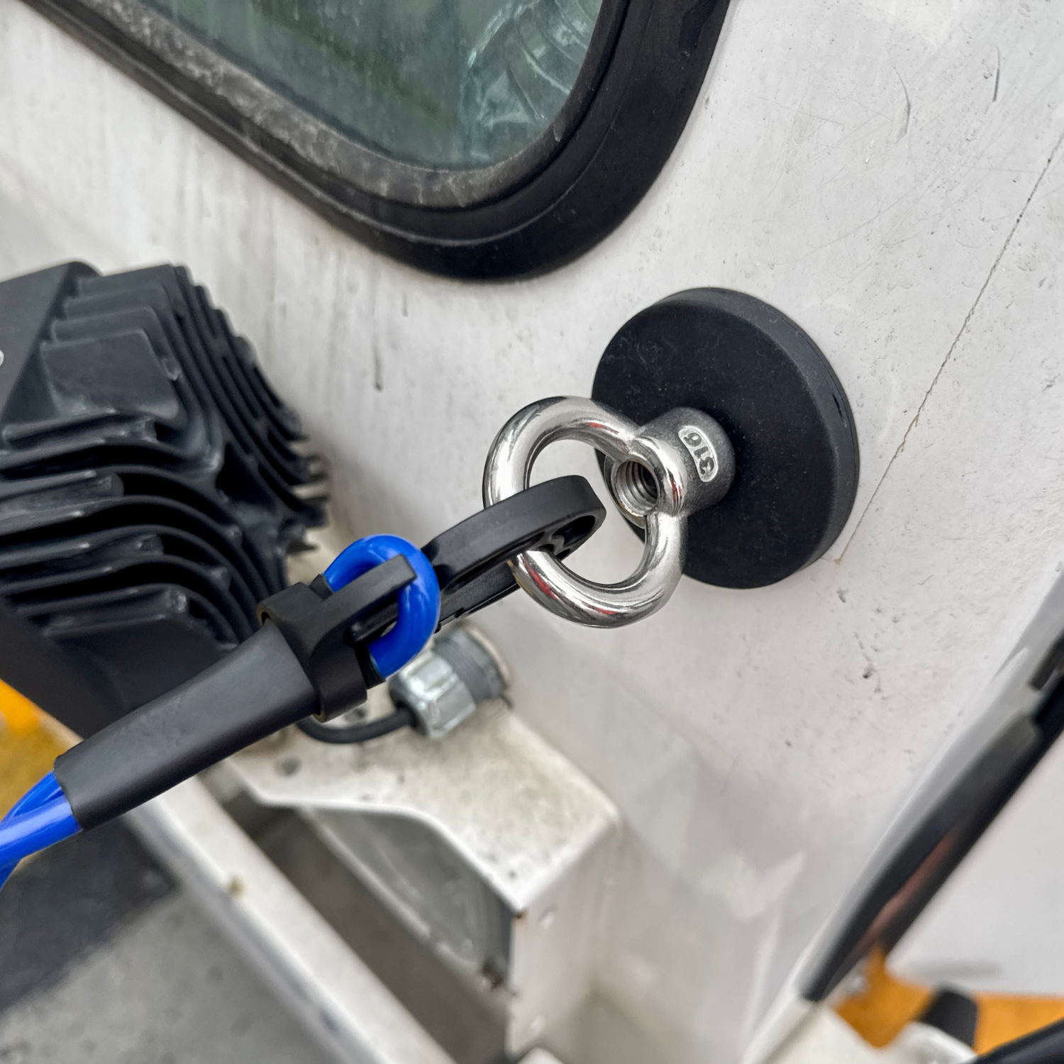 Close-up of a magnetic Pushback Tug Cable Hook attached to a metal surface on pushback Tug.